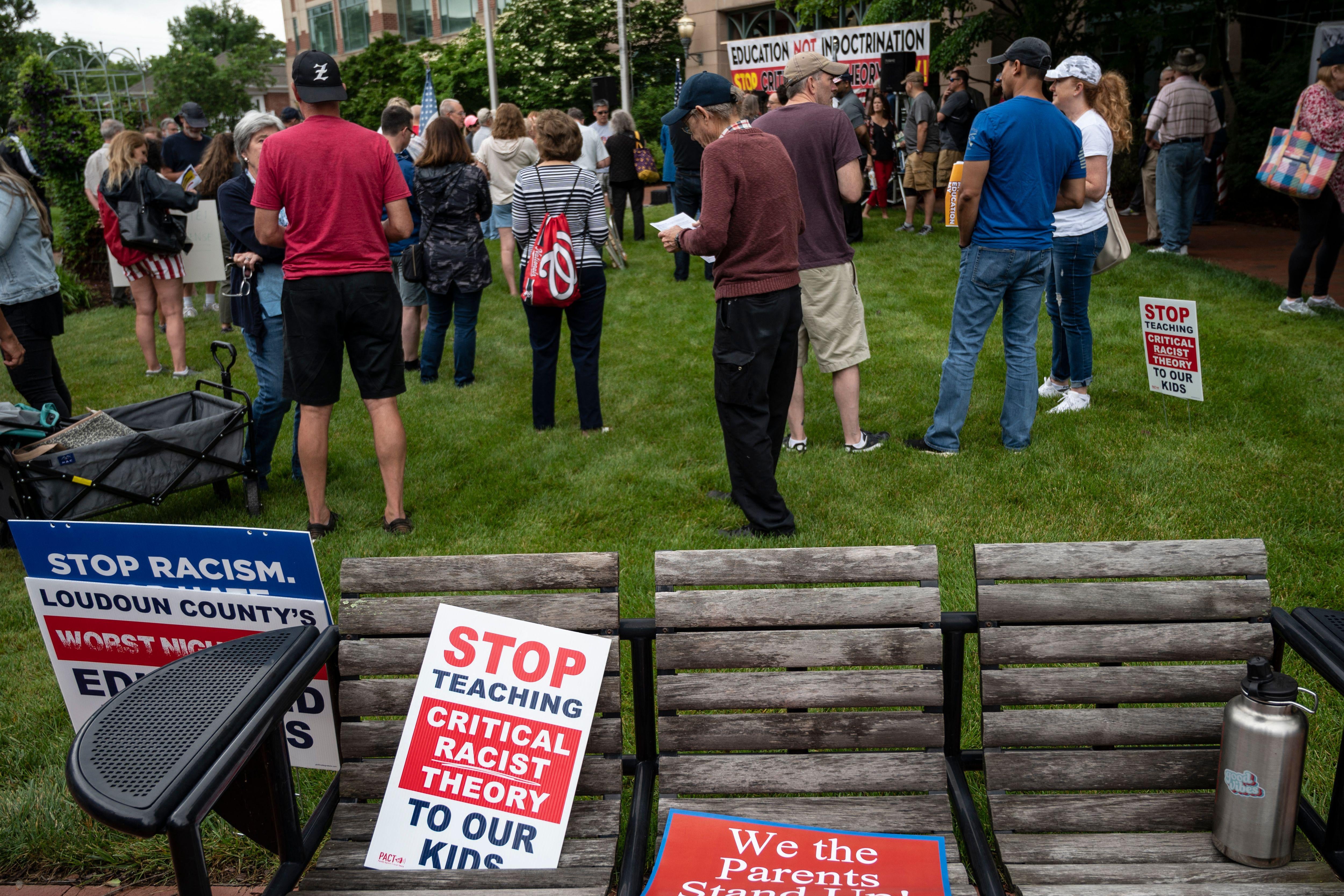 Signs that read "stop teaching critical racist theory to our kids" are seen on a bench during a rally against "critical race theory" being taught in schools at the Loudoun County Government center in Leesburg, Virginia on June 12, 2021. 