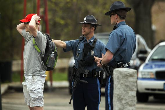 Law enforcement officers briefly detain a suspect to verify his ID on Arsenal St, in the search area for Dzhokar Tsarnaev, the one remaining suspect in the Boston Marathon bombing, in Watertown, Massachusetts April 19, 2013.