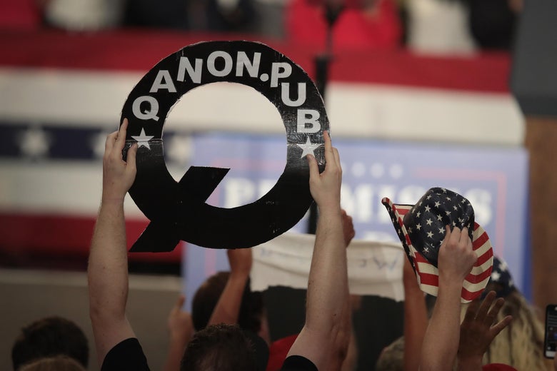 A crowd member holds up a cardboard Q.