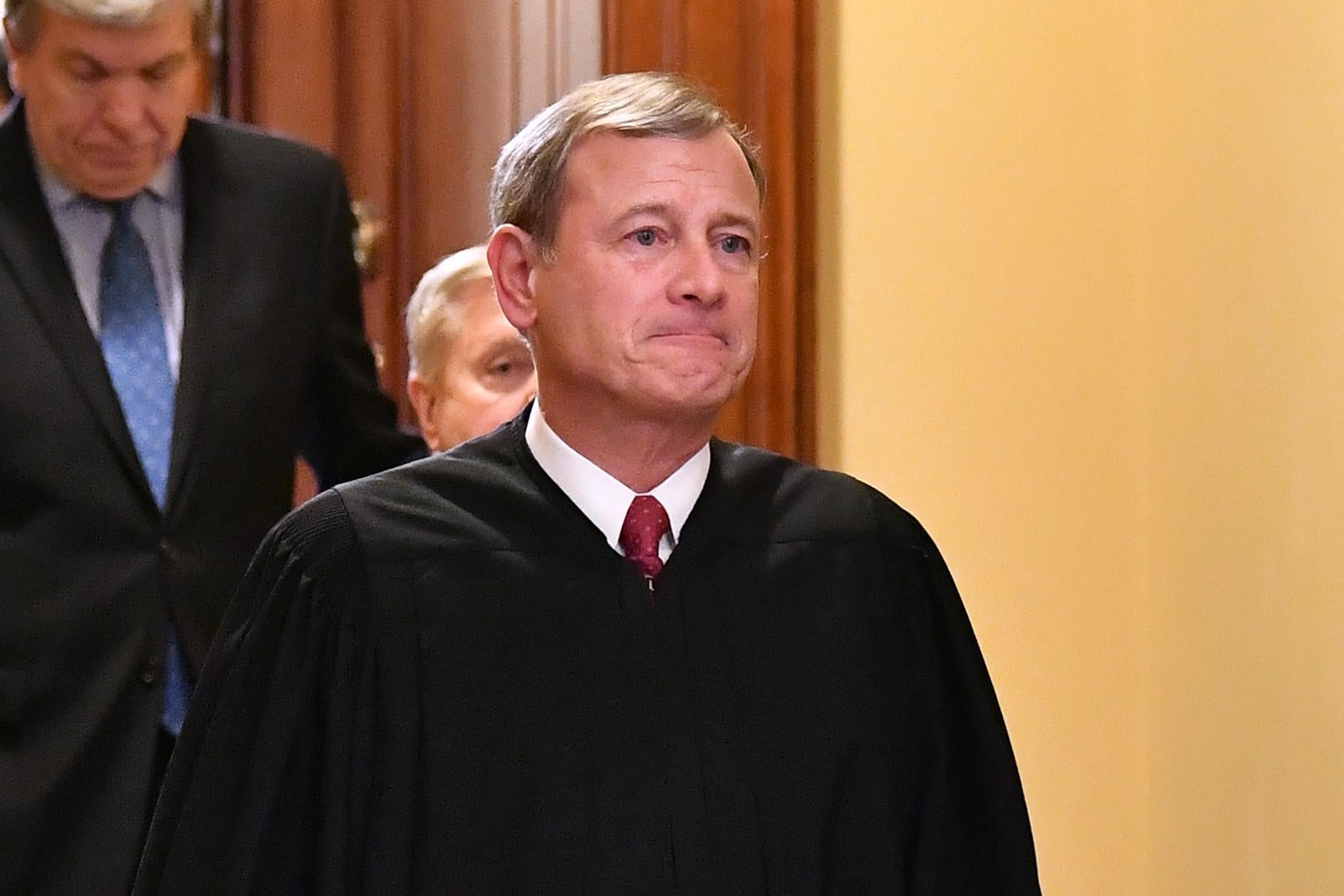 John Roberts, in robes, walks out of a room.