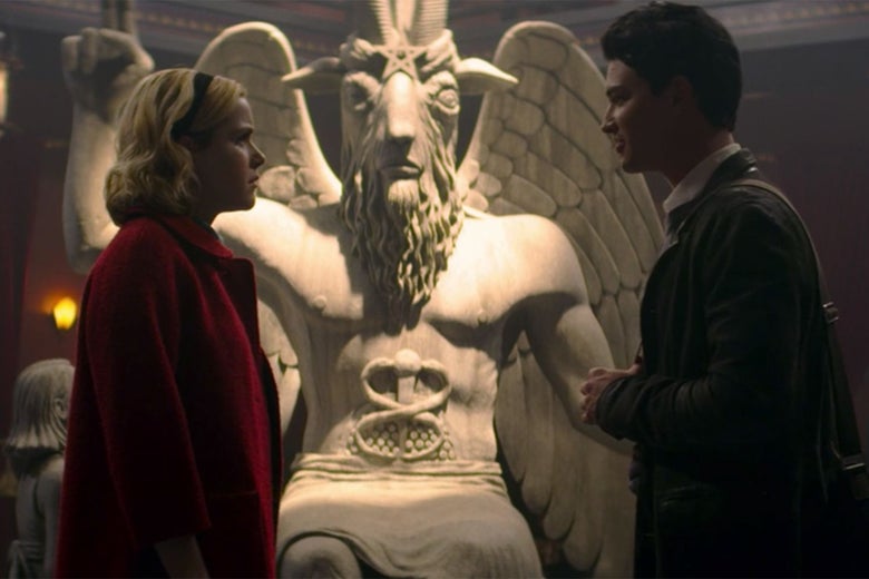 Kiernan Shikpa's Sabrina stands in front of a statue of a goat-headed deity.