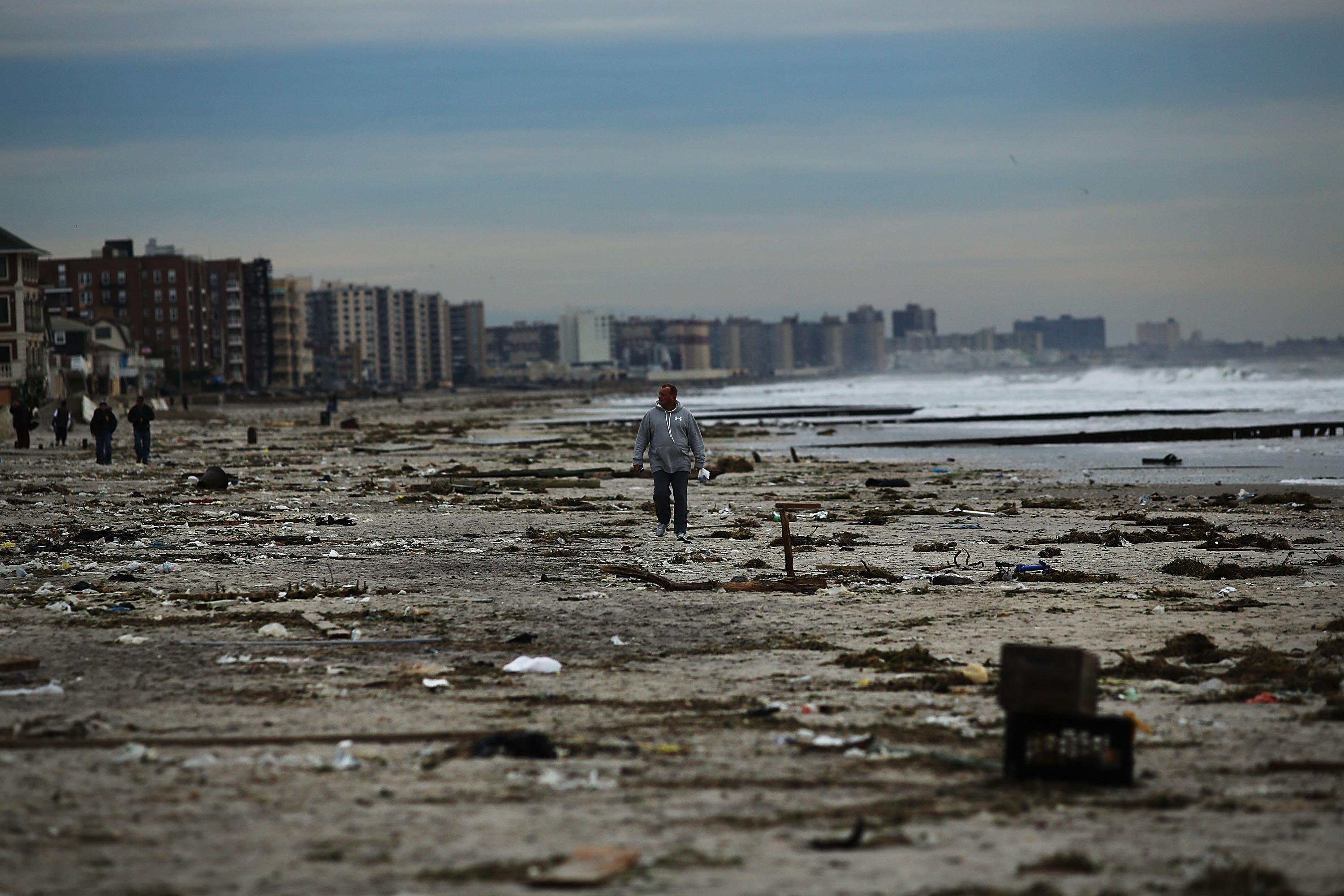 A man walks along the beach in the heavily damaged Rockaway neighborhood, in Queens where a large section of the iconic boardwalk was washed away on November 2, 2012 in New York.
