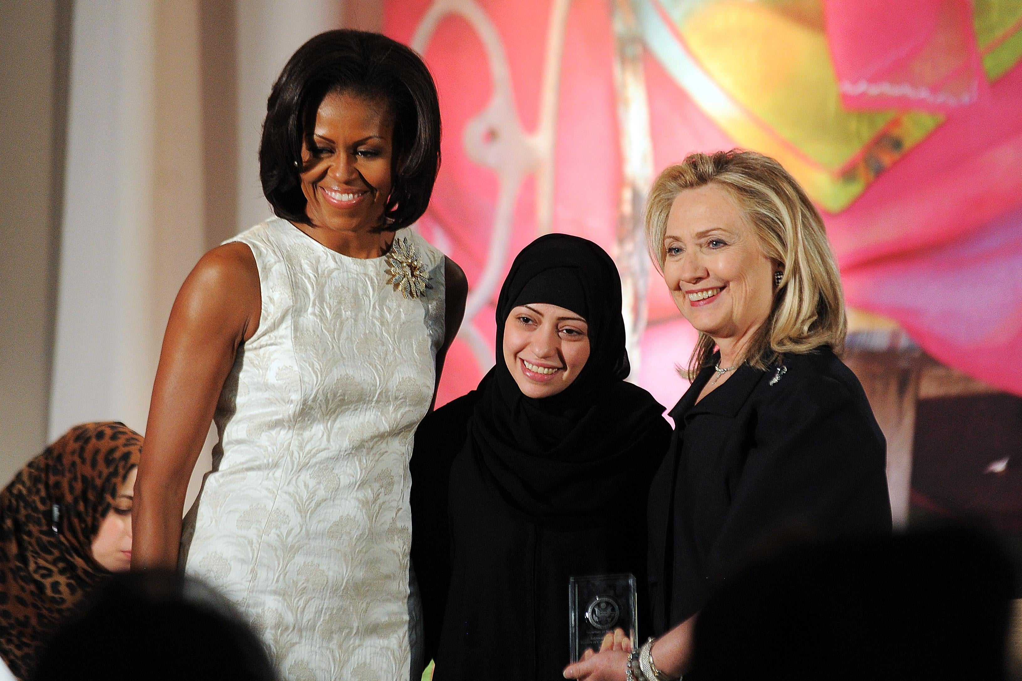 Michelle Obama and Hillary Clinton pose with Samar Badawi as she receives the 2012 International Women of Courage Award.
