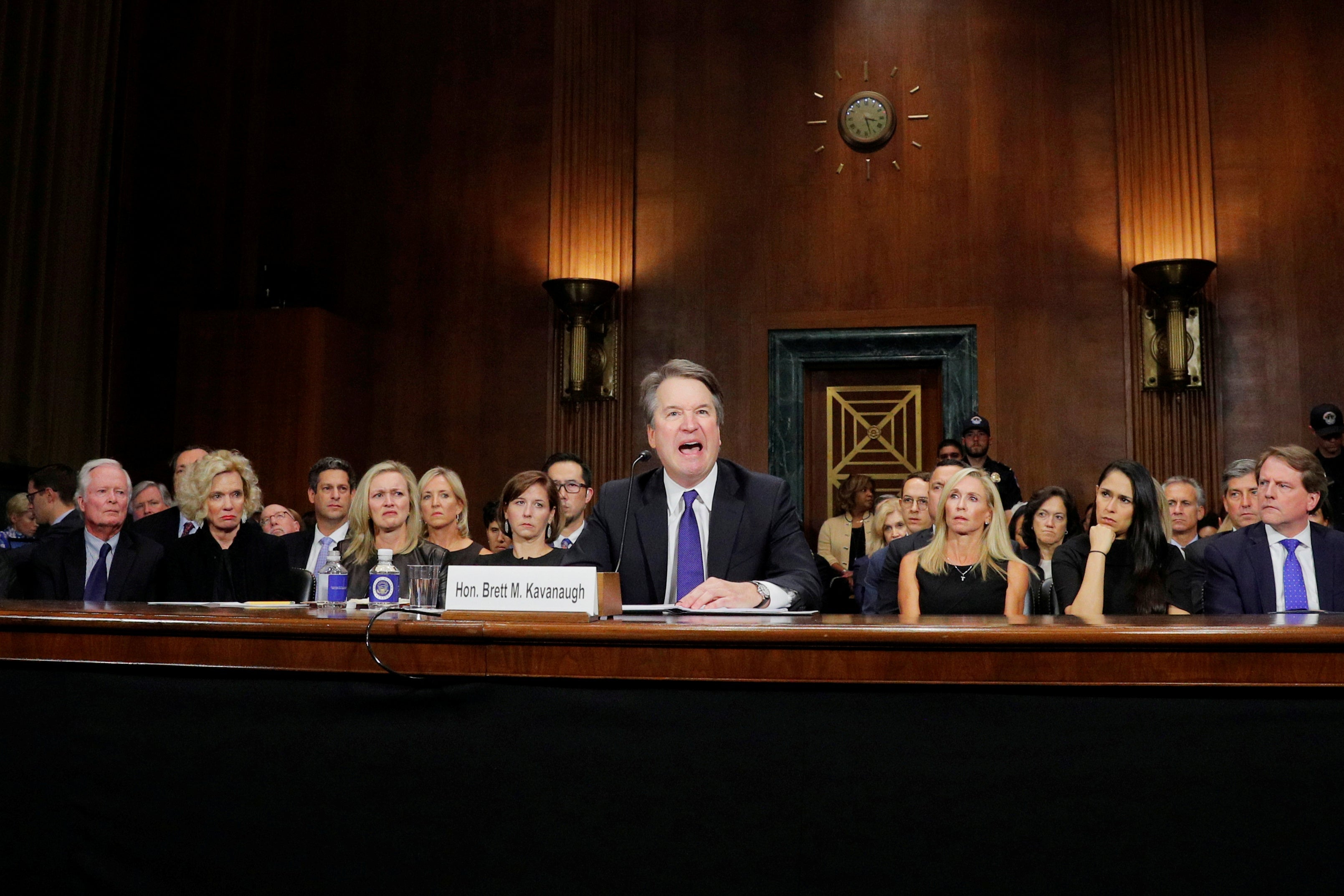 Kavanaugh yelling. Behind him, women seated in the front row look disgusted.