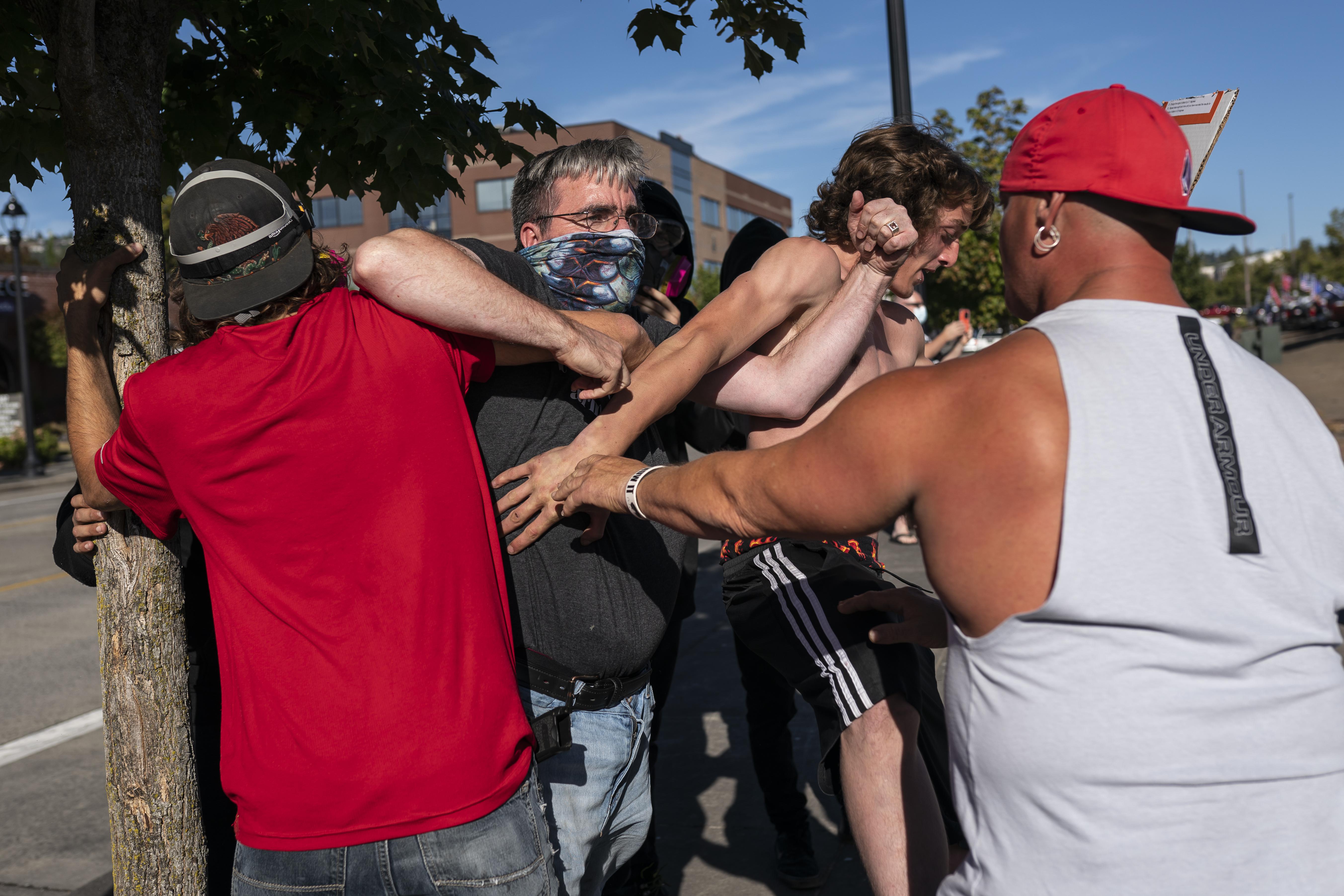 A Black Lives Matter protester scuffles with attendees of a pro-Trump rally during an event held to show support for the president on August 29, 2020 in Clackamas, Oregon. 