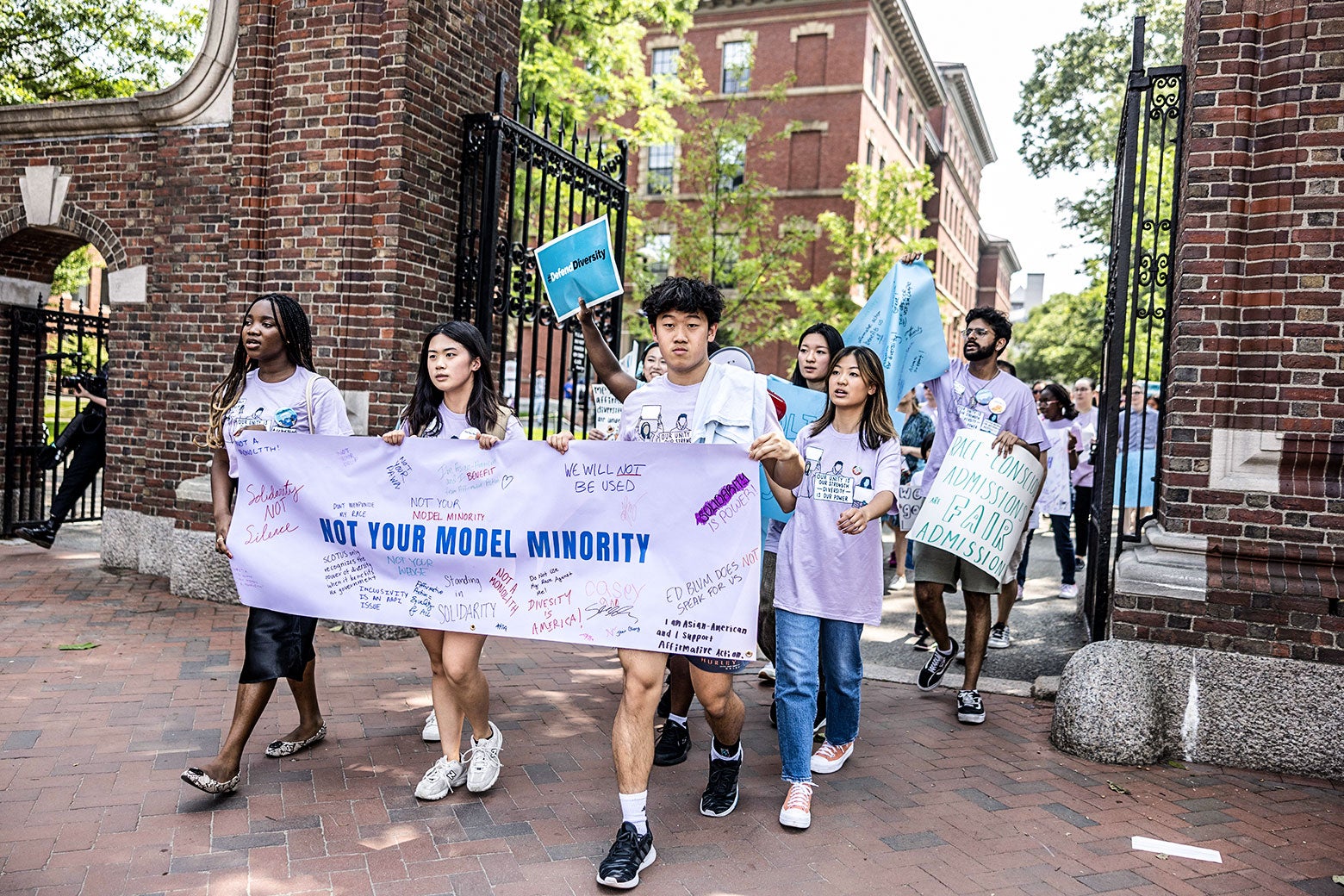 Students and others march through Harvard University while holding up a banner in support of affirmative action.