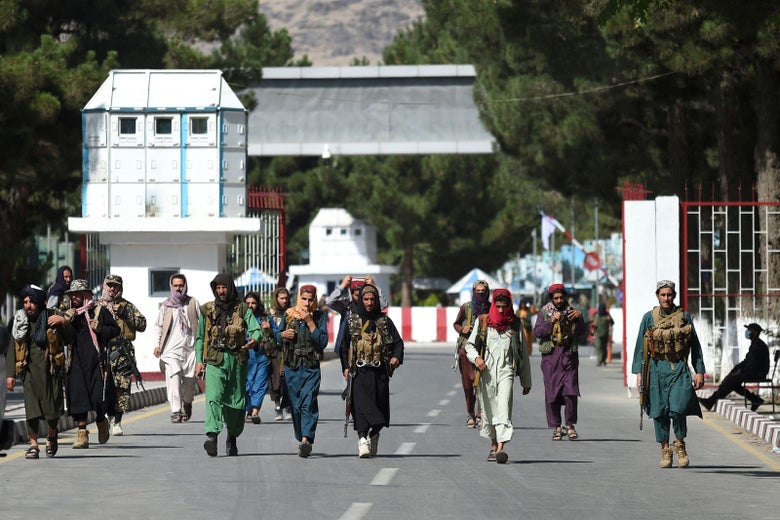 Taliban fighters walk at the main entrance gate of Kabul airport in Kabul on August 28, 2021.