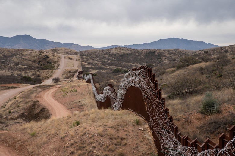 A border fence winds through the land on the outskirts of Arizona