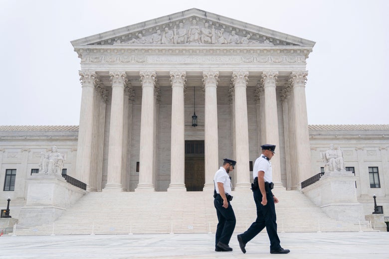 Police officers walk in front of the U.S. Supreme Court.