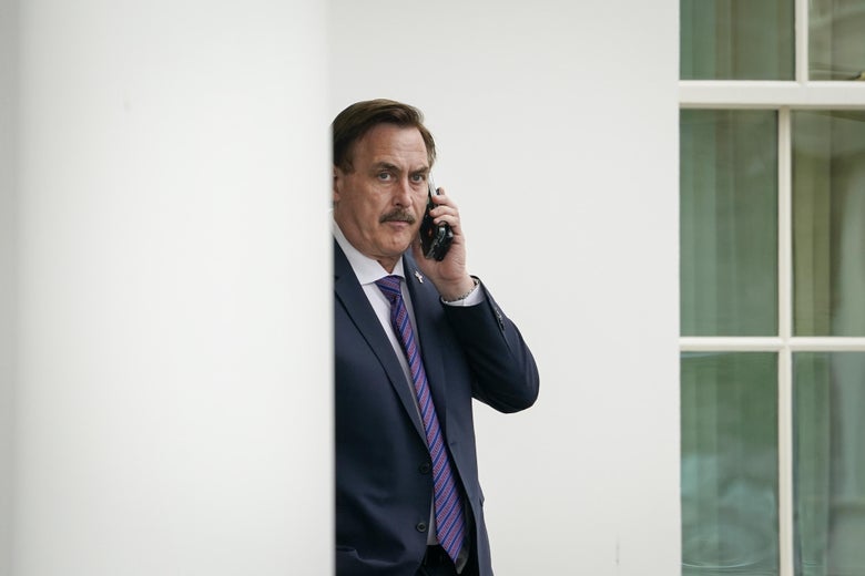 Lindell holds a cellphone to his ear while standing outside the White House.