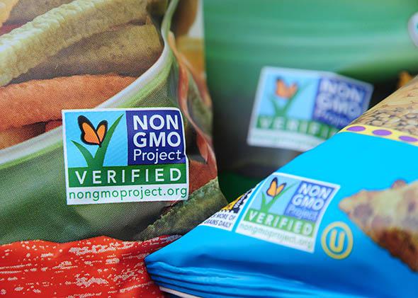 Labels on bags of snack foods indicate they are non-GMO food products.