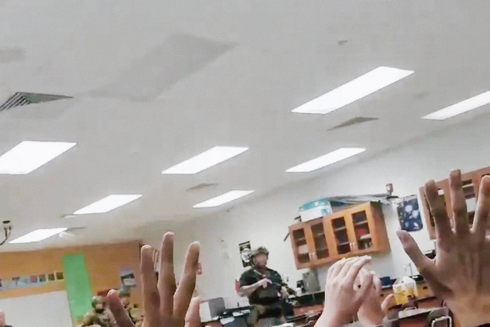Students put their hands up in the air as armed police enter their classroom, following a shooting at the Marjory Stoneman Douglas High School in Parkland, Florida, in this screengrab taken from a Feb. 14 social media video.