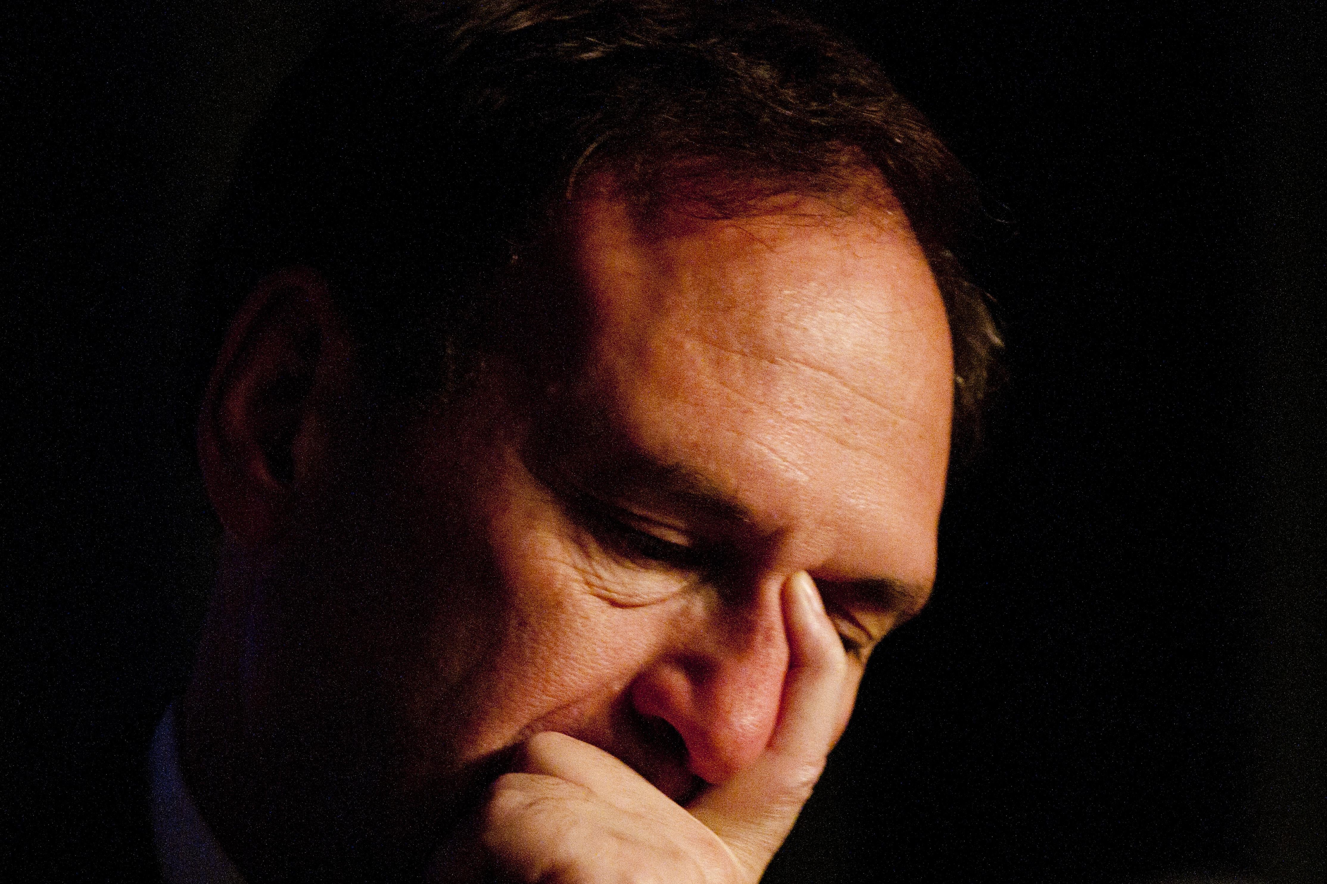 Close-up of Alito holding his face in his hand with eyes downcast