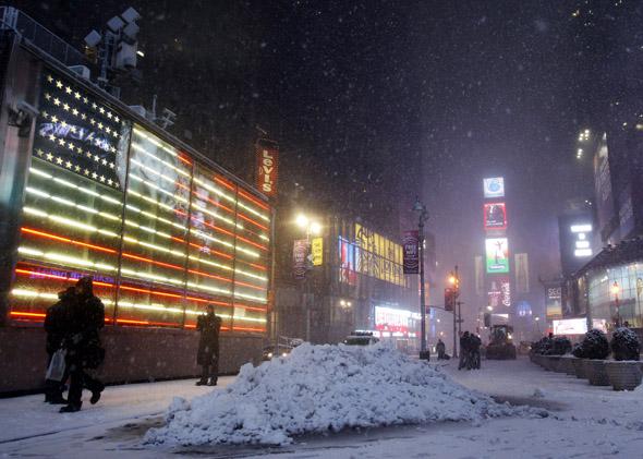 People walk through Times Square during a snowstorm in New York January 26, 2011. 