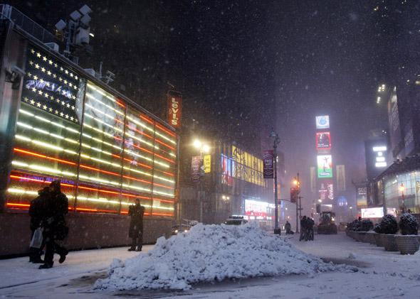 People walk through Times Square during a snowstorm in New York January 26, 2011.