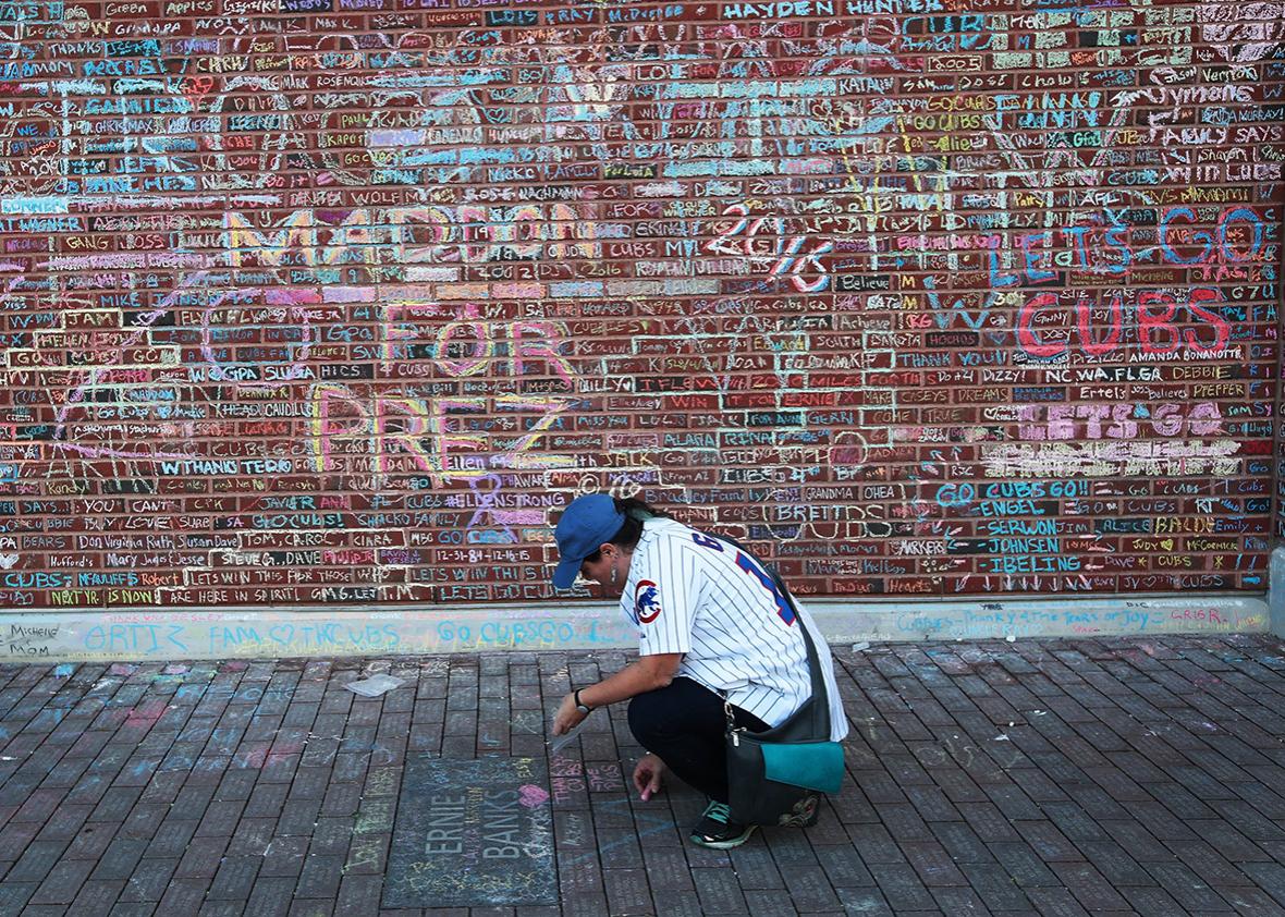 Chicago Cubs fan Stacey Shroyer Piotrowski chalks a message on a sidewalk outside Wrigley Field the day after the Cubs defeated the Cleveland Indians to win the 2016 World Series on November 3, 2016 in Chicago, Illinois. 