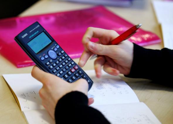 A high-school student uses a calculator. 