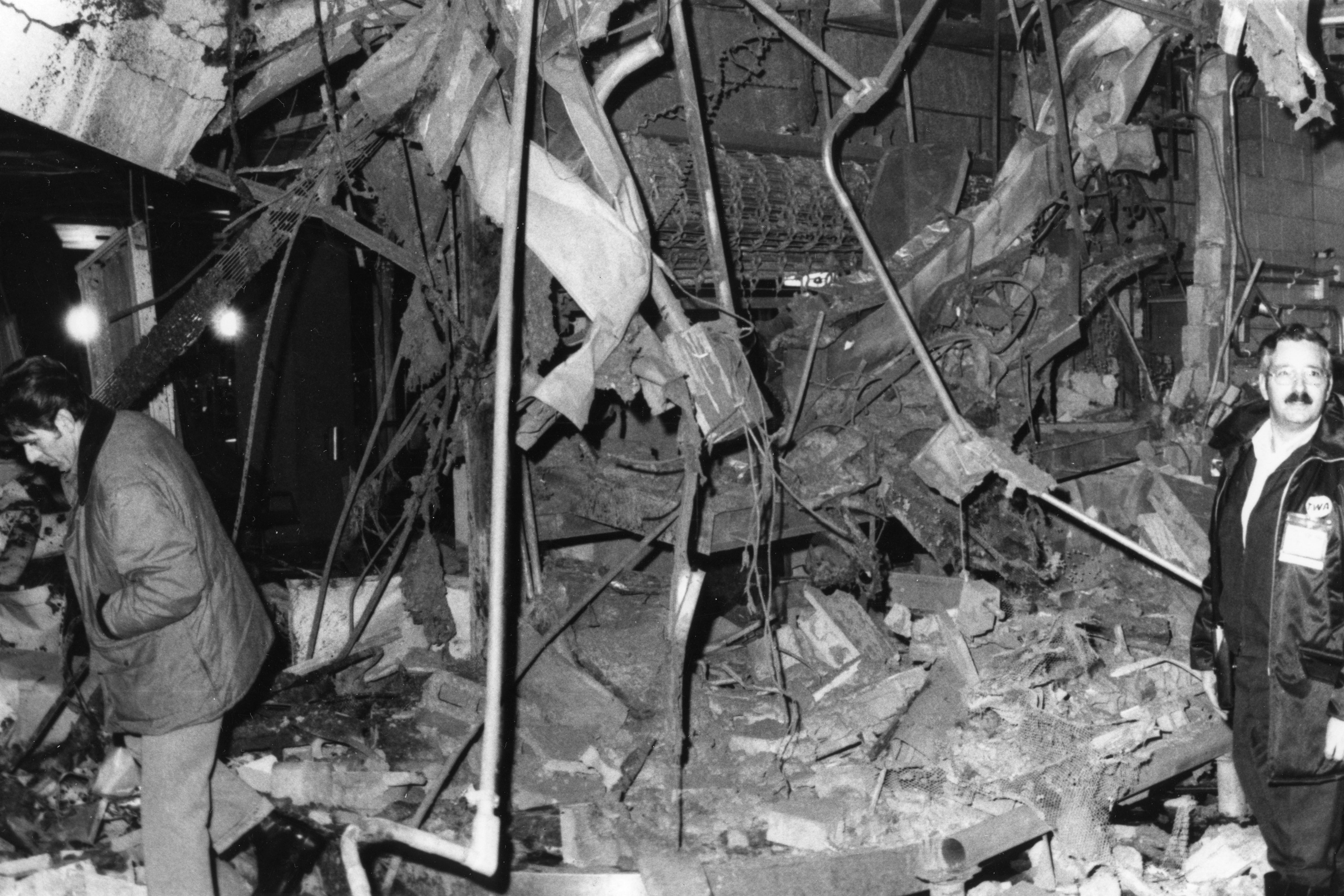 Two men make their way through dangling rubble. 