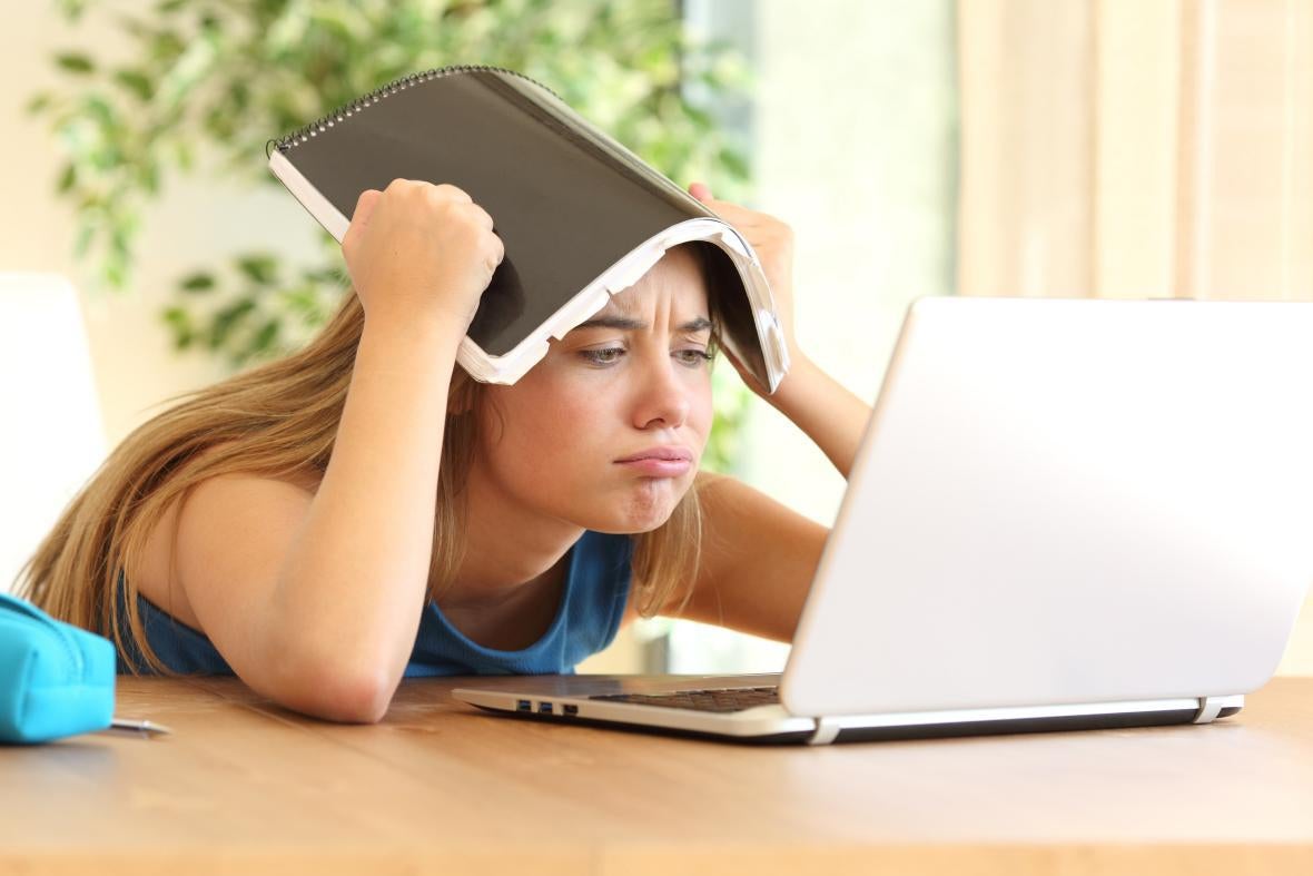 woman with book on head looking frustrated