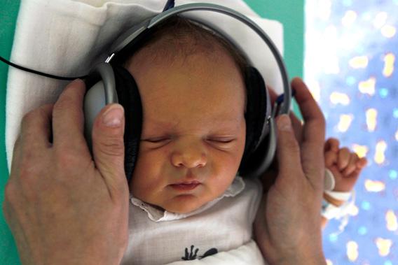 A nurse adjusts earphones playing relaxing music to a newborn baby in Kosice, east Slovakia May 2011.
