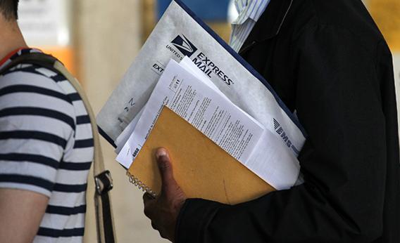 A U.S. Postal Service customer holds his tax returns as he waits in line to mail them at the James A. Farley Post Office on April 17, 2012 in New York City. 