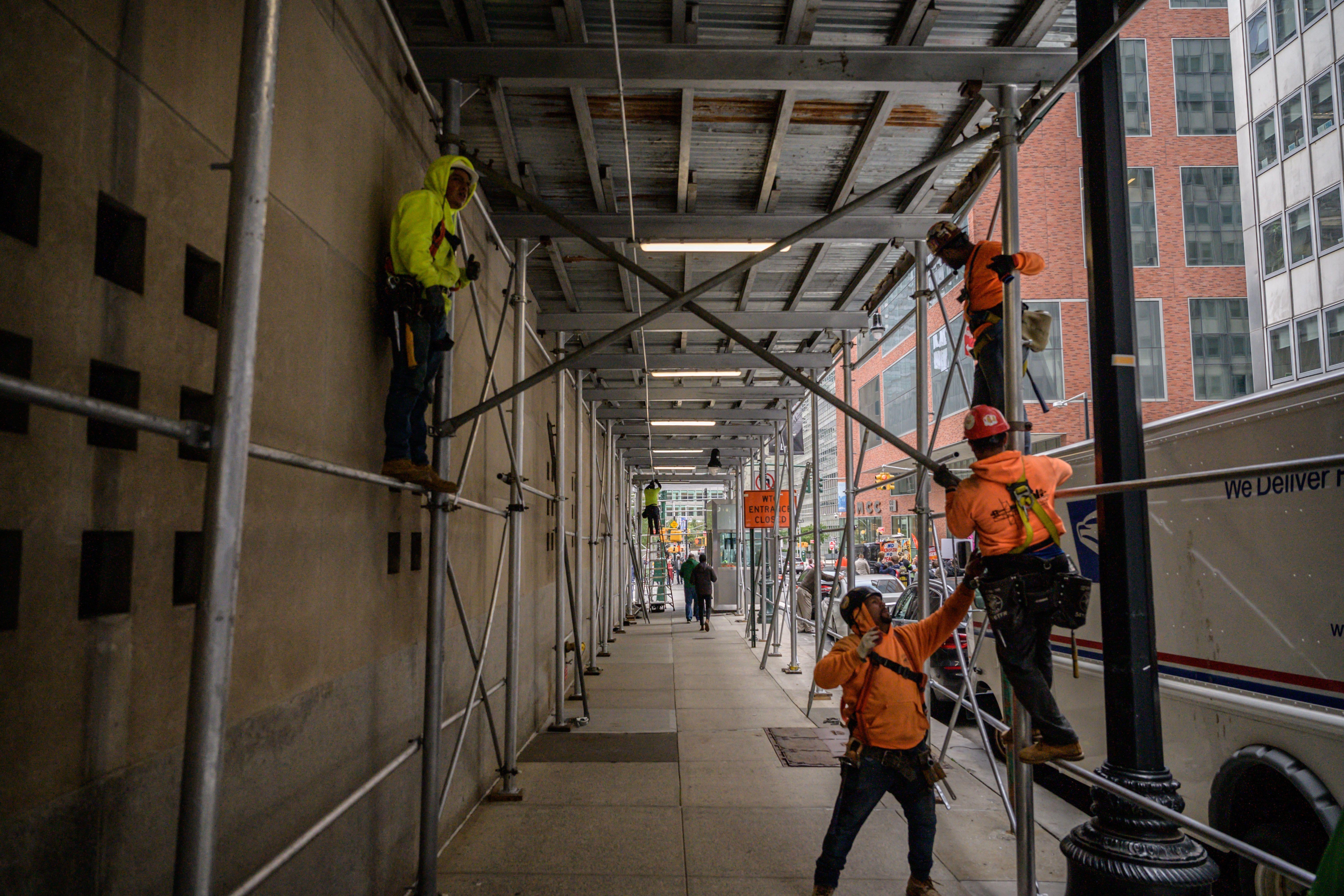 Construction workers erect scaffolding on a street in Manhattan, New York city on October 29, 2021.