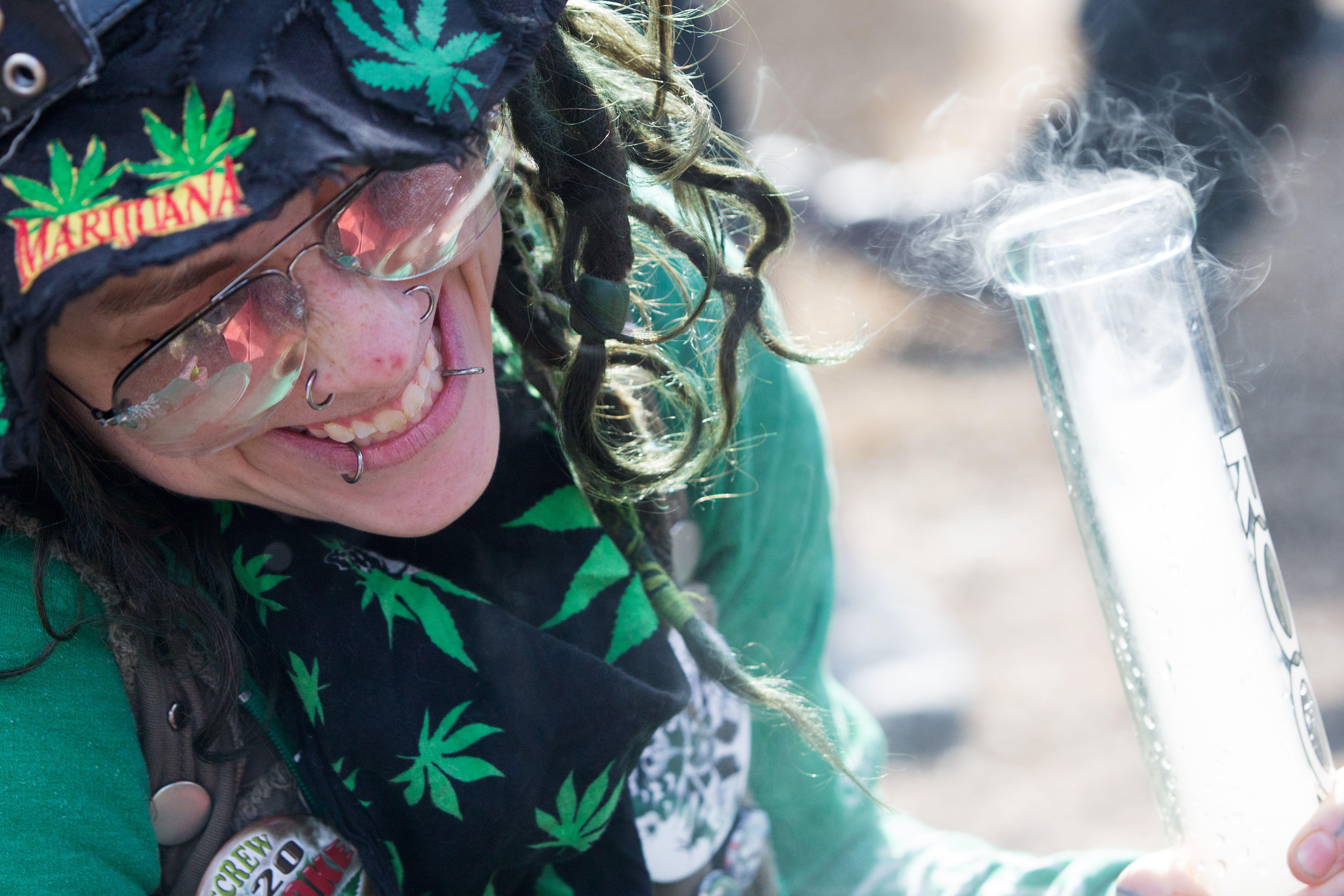 A woman inhales marijuana during the annual 4/20 rally on Parliament Hill in Ottawa, Ontario on April 20, 2018. 