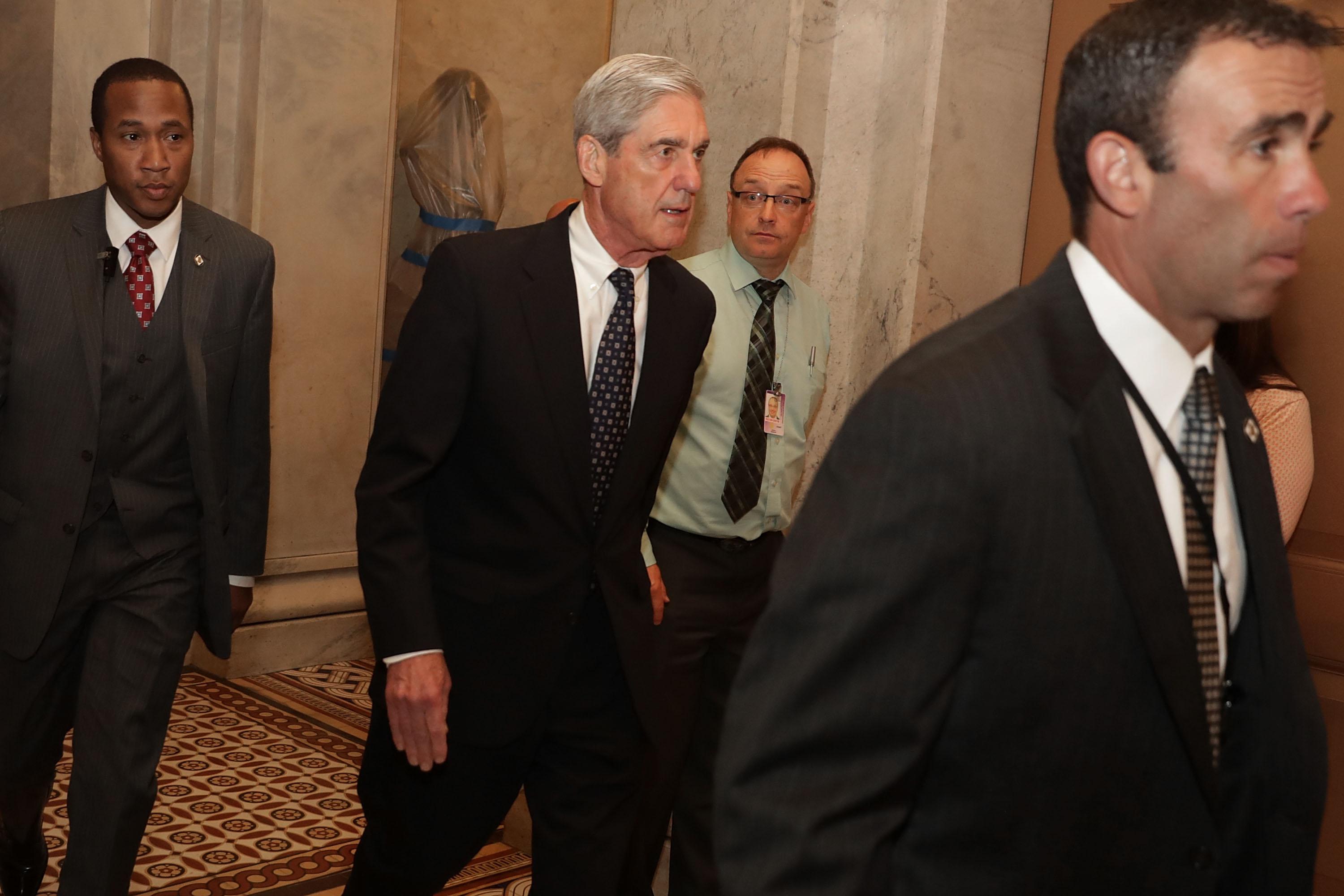 Former FBI Director Robert Mueller is surrounded by security and staff as he leaves a meeting with senators at the U.S. Capitol June 21, 2017 in Washington, DC. 