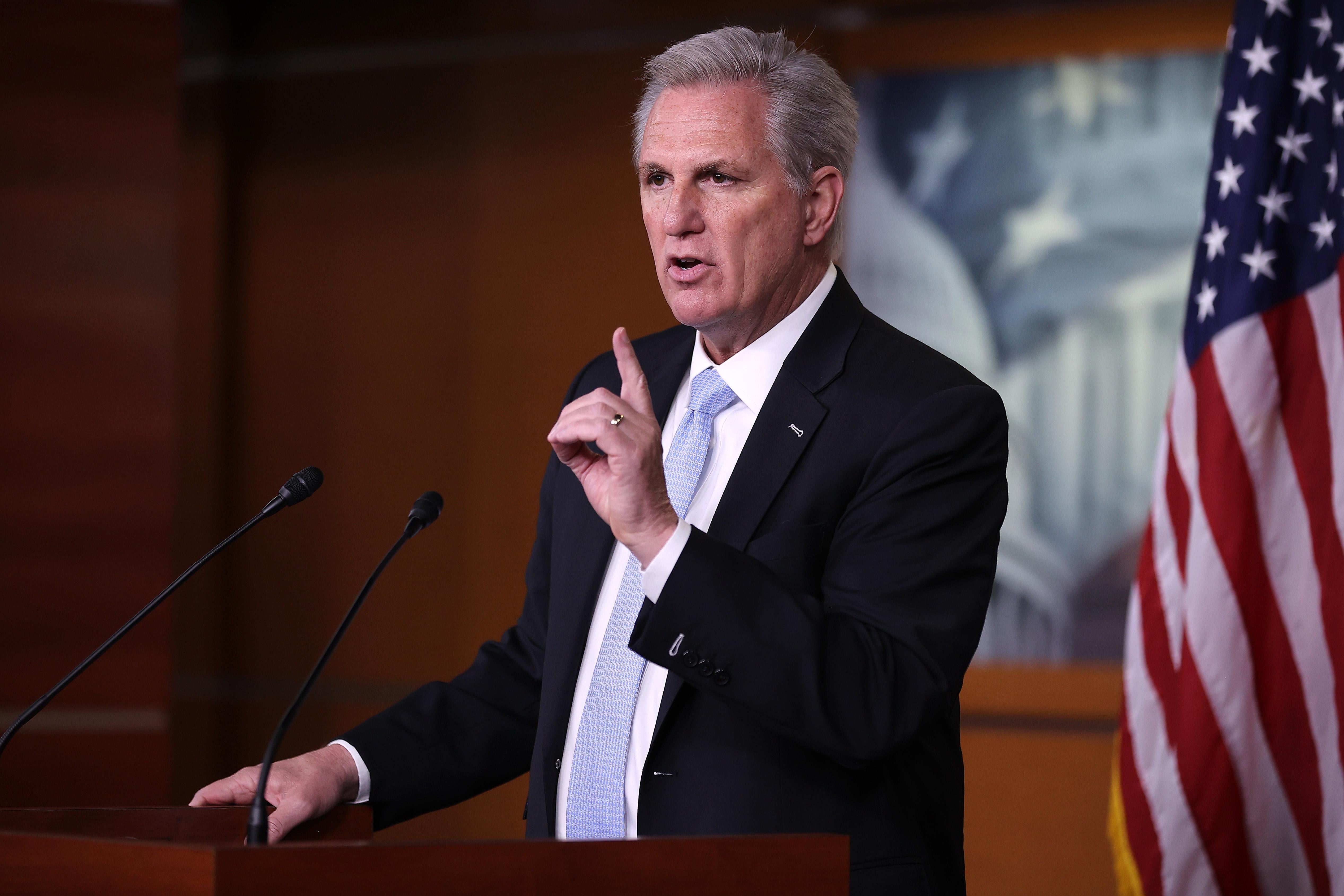 Kevin McCarthy making the gesture for "one" while speaking behind a mic