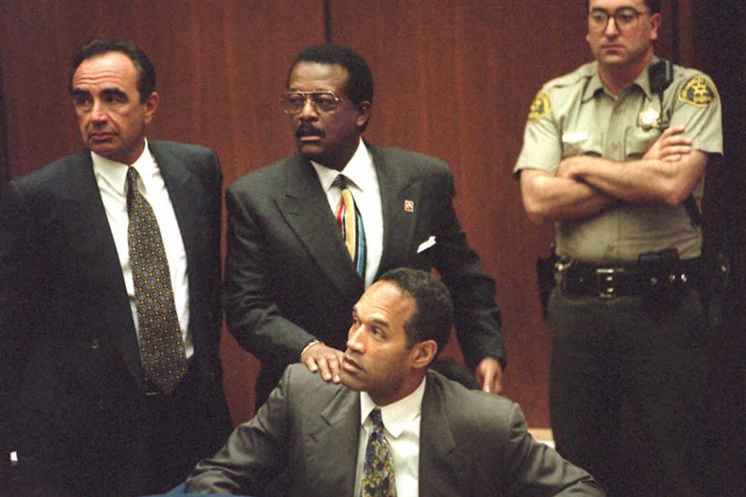 Johnnie Cochran Jr. puts his hand on the shoulder of O.J. Simpson during a hearing.