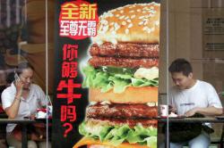 Customers finish their meal at a branch of McDonalds in Beijing, 20 June 2006.
