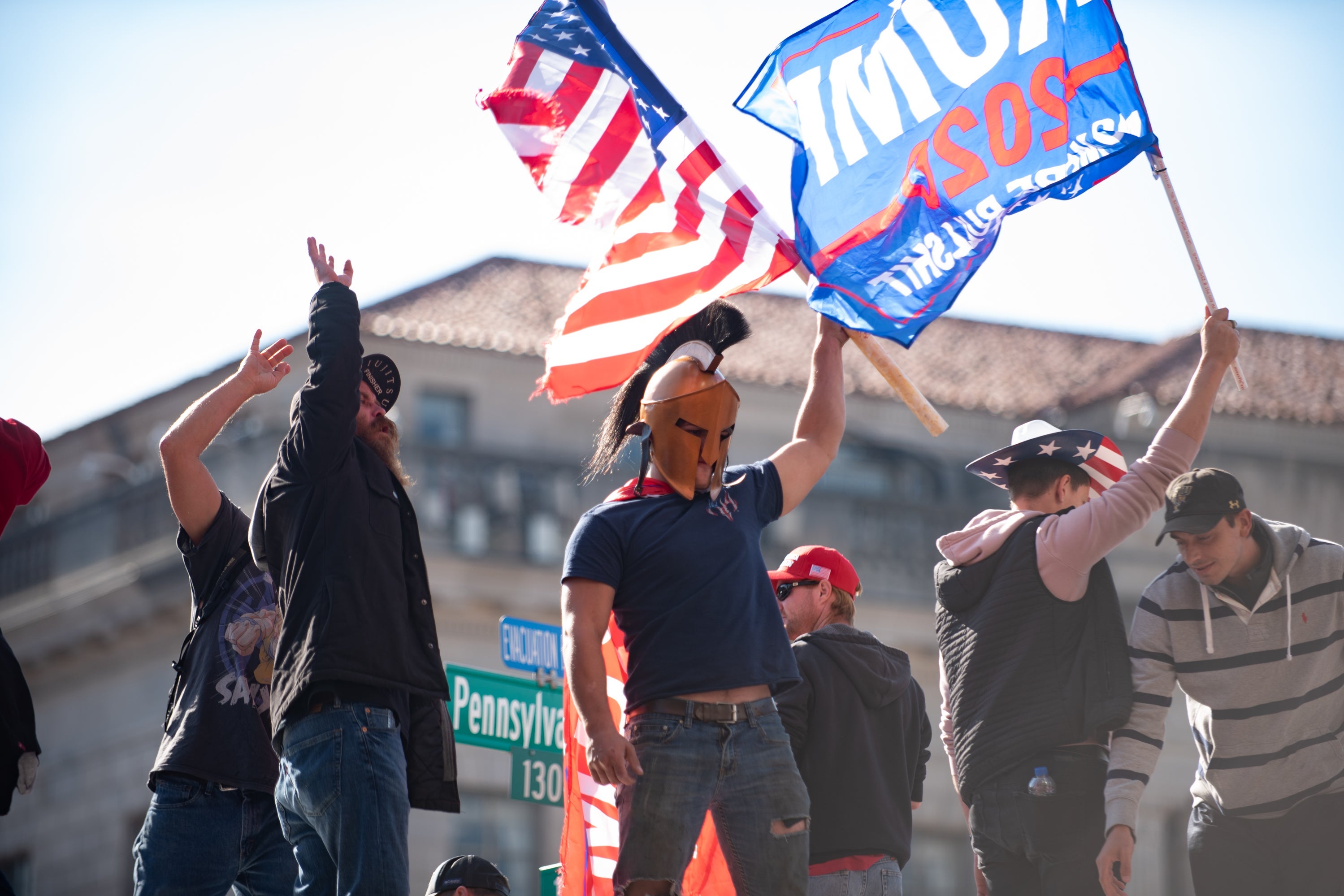 A man wearing a homemade Spartan helmet waves a flag among thousands of Trump loyalists who converged on Washington DC on Saturday for the Million MAGA March.