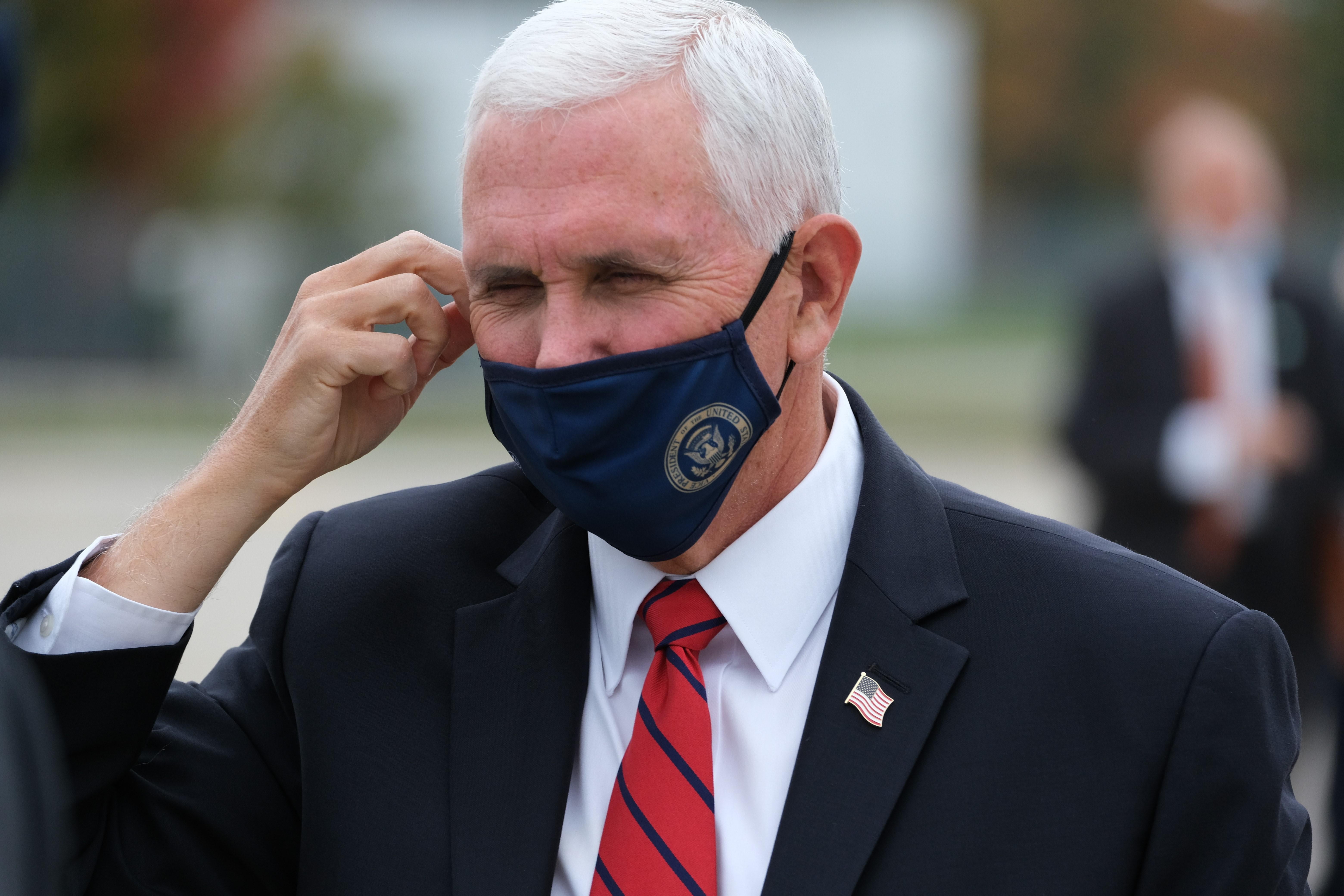 Mike Pence adjusts his facemask. 