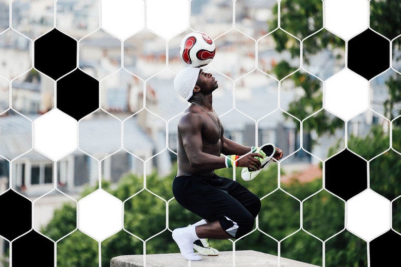 Iya Traore, a former professional football player, balances a football on his head as he performs for visitors in the Montmartre area of Paris. 
