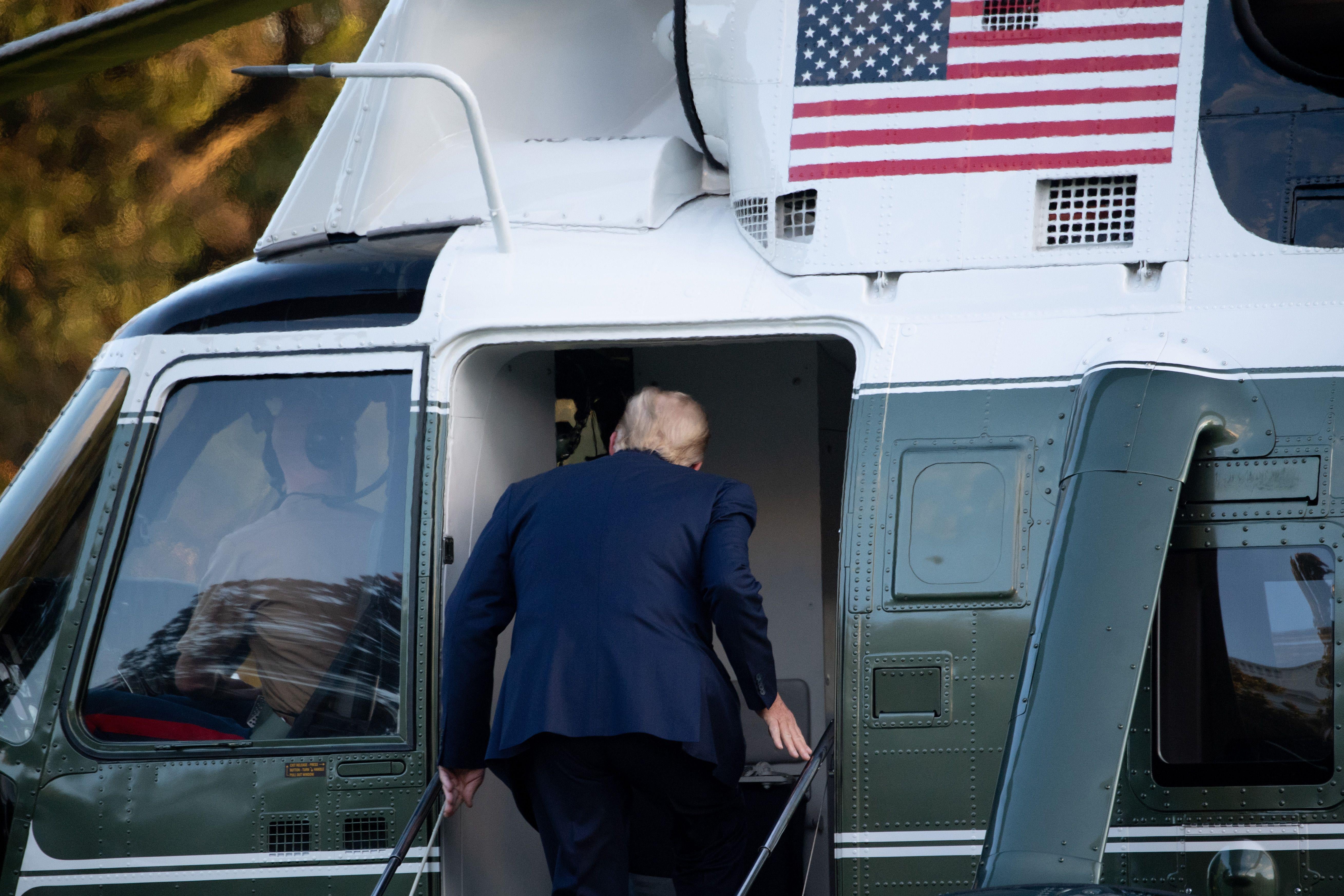 Donald Trump enters a helicopter.