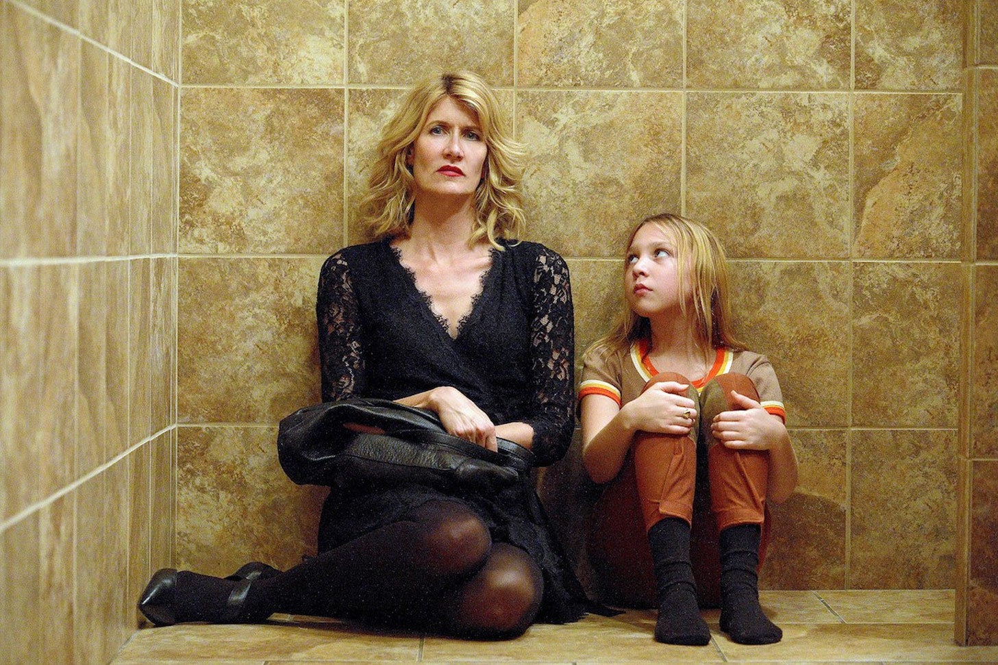 Laura Dern and Isabelle Nélisse sit next to each other on a tile floor in this promotional image for The Tale.