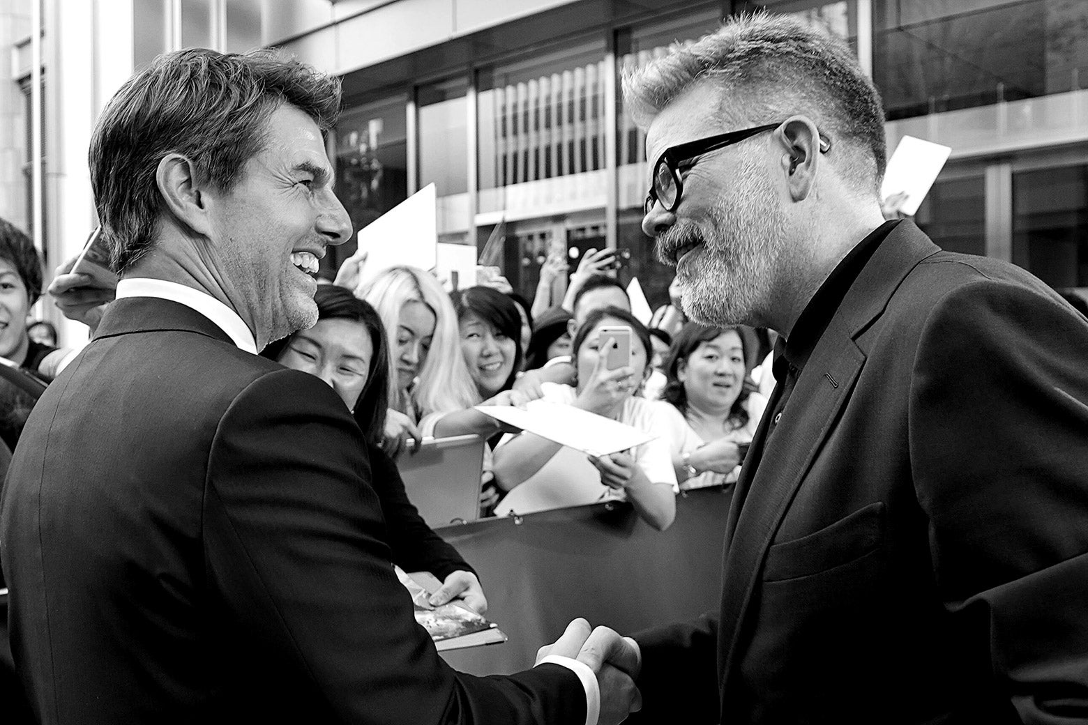 Tom Cruise and Christopher McQuarrie shake hands.