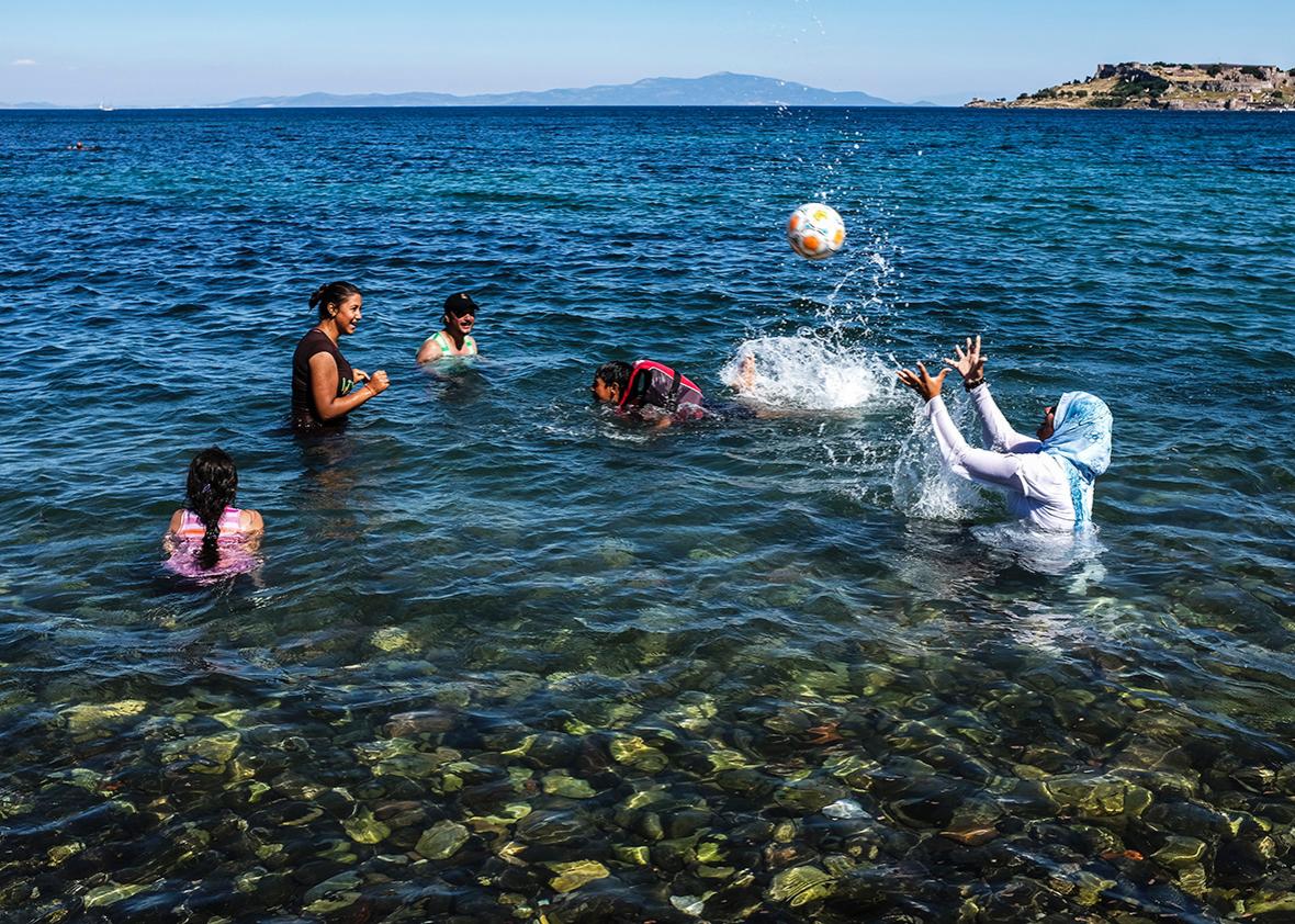 Women and children play in the water off the island of Lesbos on June 12.