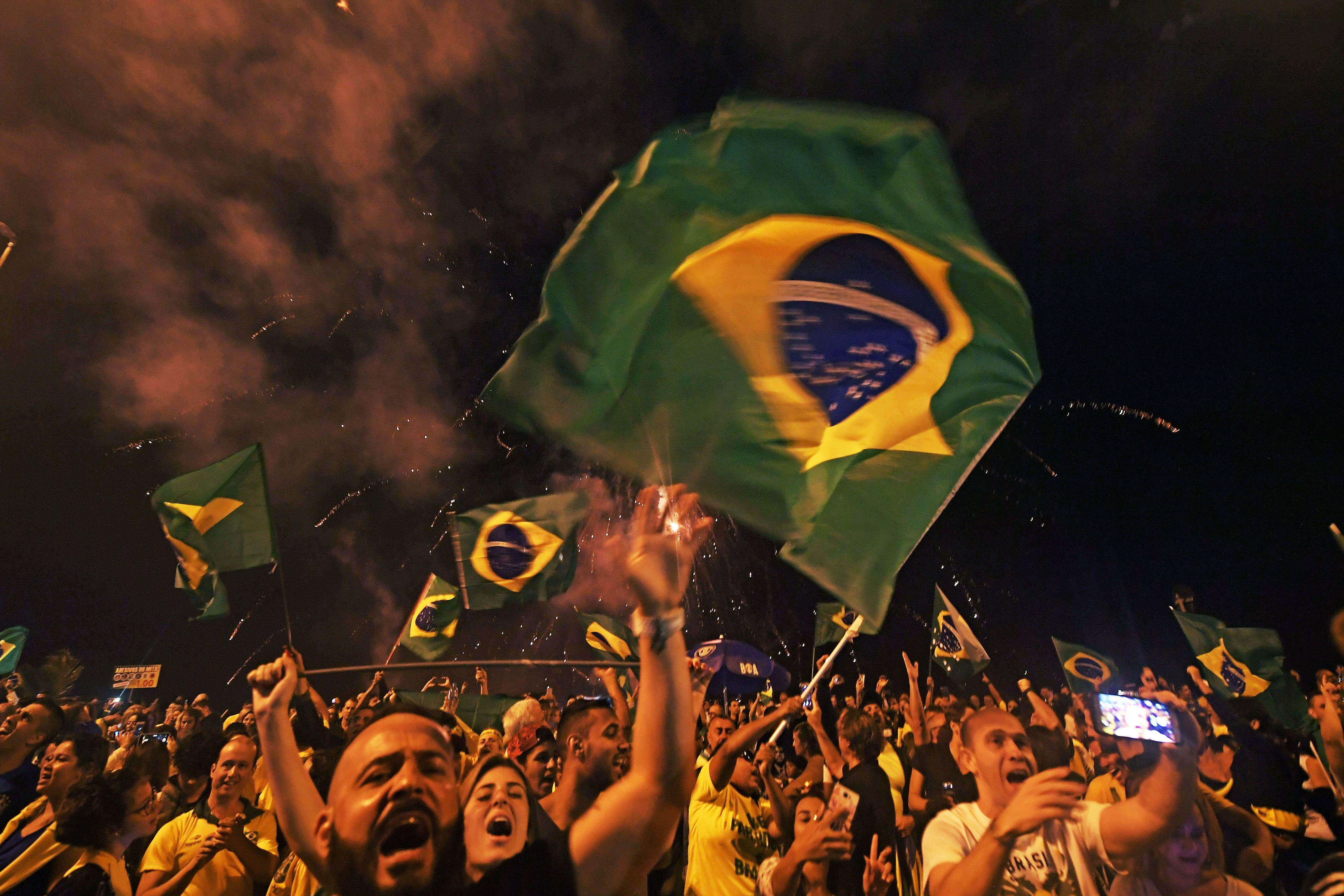 Supporters of far-right lawmaker and presidential candidate for the Social Liberal Party (PSL), Jair Bolsonaro, celebrate in Rio de Janeiro, after the former army captain won Brazil's presidential election on October 28, 2018. 