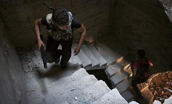 Free Syrian Army fighters run up the stairs of a building in Aleppo's Salaheddine neighborhood.