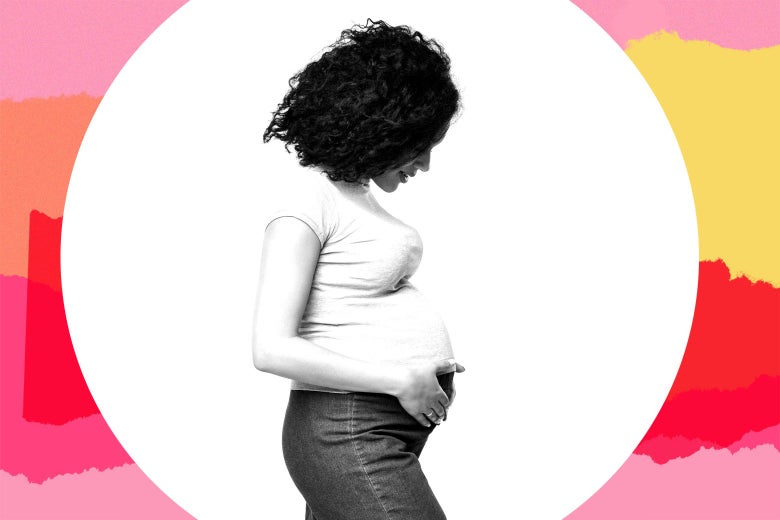 A woman holding her pregnant stomach and looking down at it.
