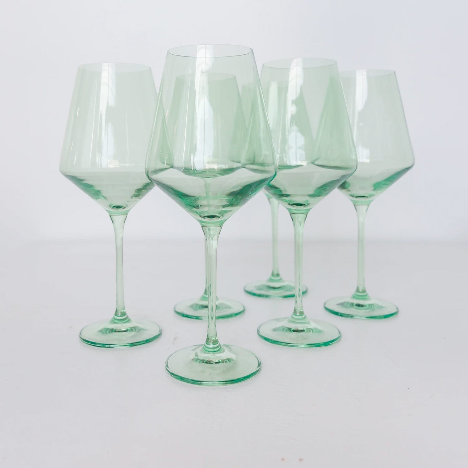 Six stemmed wine glasses made of green colored glass