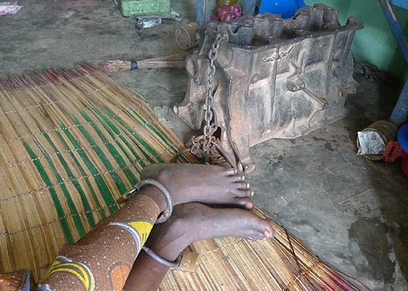 A mentally ill patient shackled to an engine block at the Olaiya Naturalist Hospital in Ibadan, Nigeria.