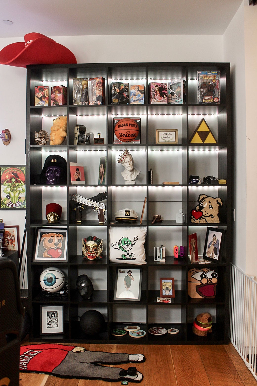 A bookcase packed with anime, a Darth Vader mask, and other nerdy memorabilia.