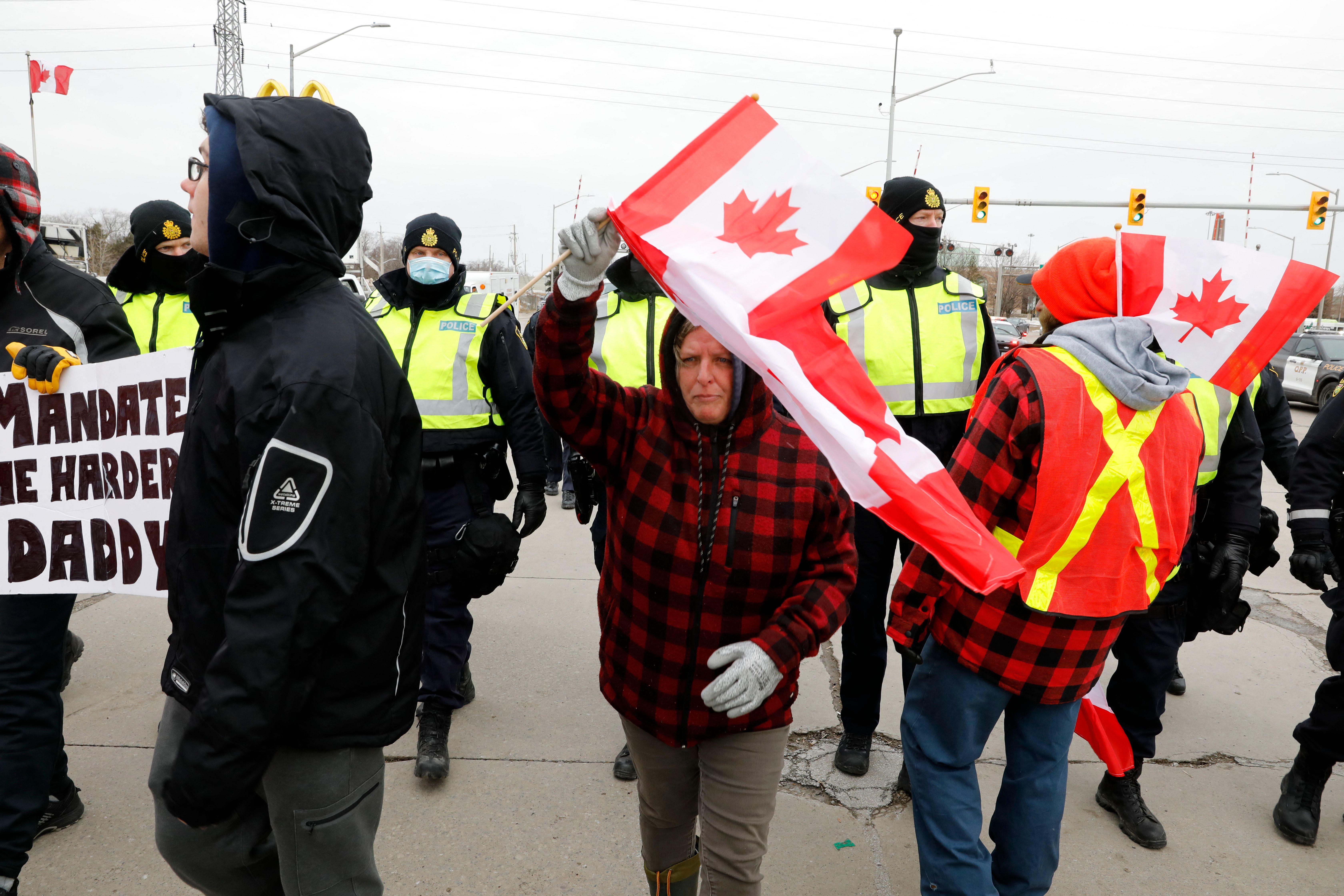 Ontario Provincial Police move protestors against Covid-19 vaccine mandates as they try to clear the entrance to the Ambassador Bridge in Windsor, Ontario, Canada, on February 12, 2022.