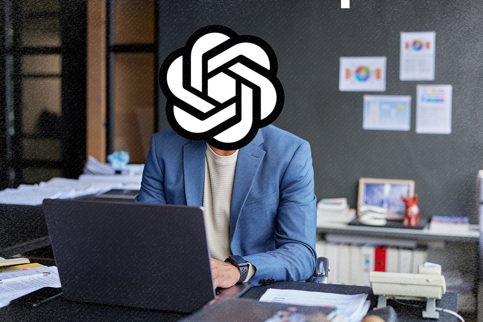 A man in a blue suit at a desk in front of an open laptop. The man's head is the OpenAI logo. 