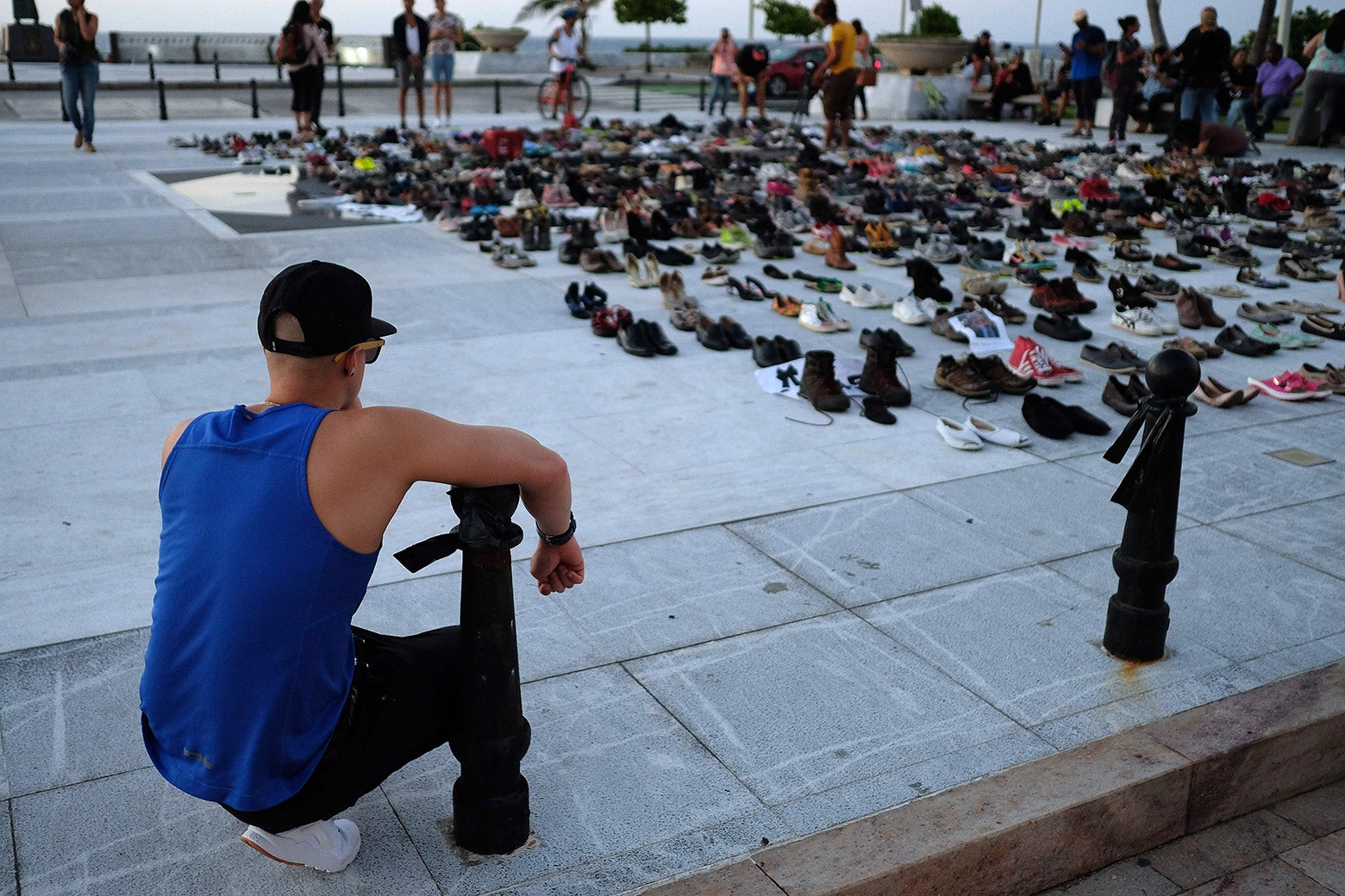 A man looks at hundreds of shoes displayed in memory of those killed by Hurricane Maria.