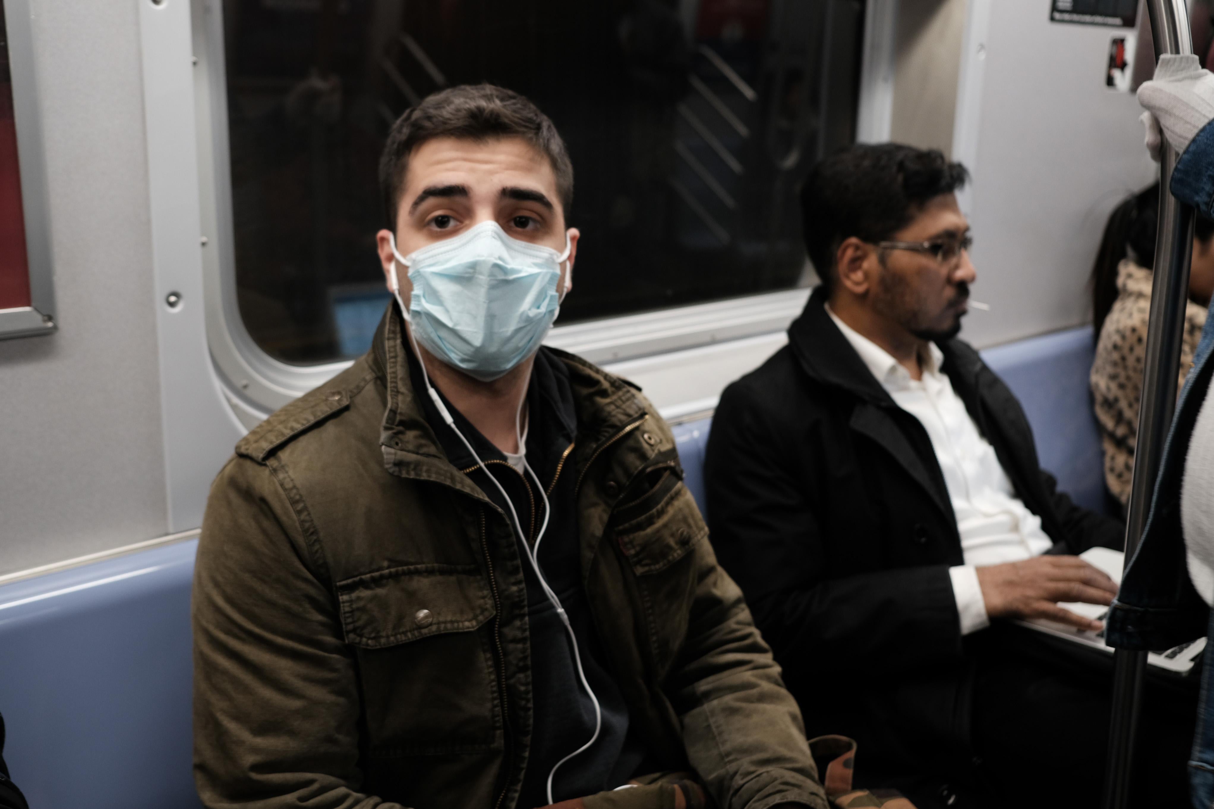 A man wearing a face mask on the subway.