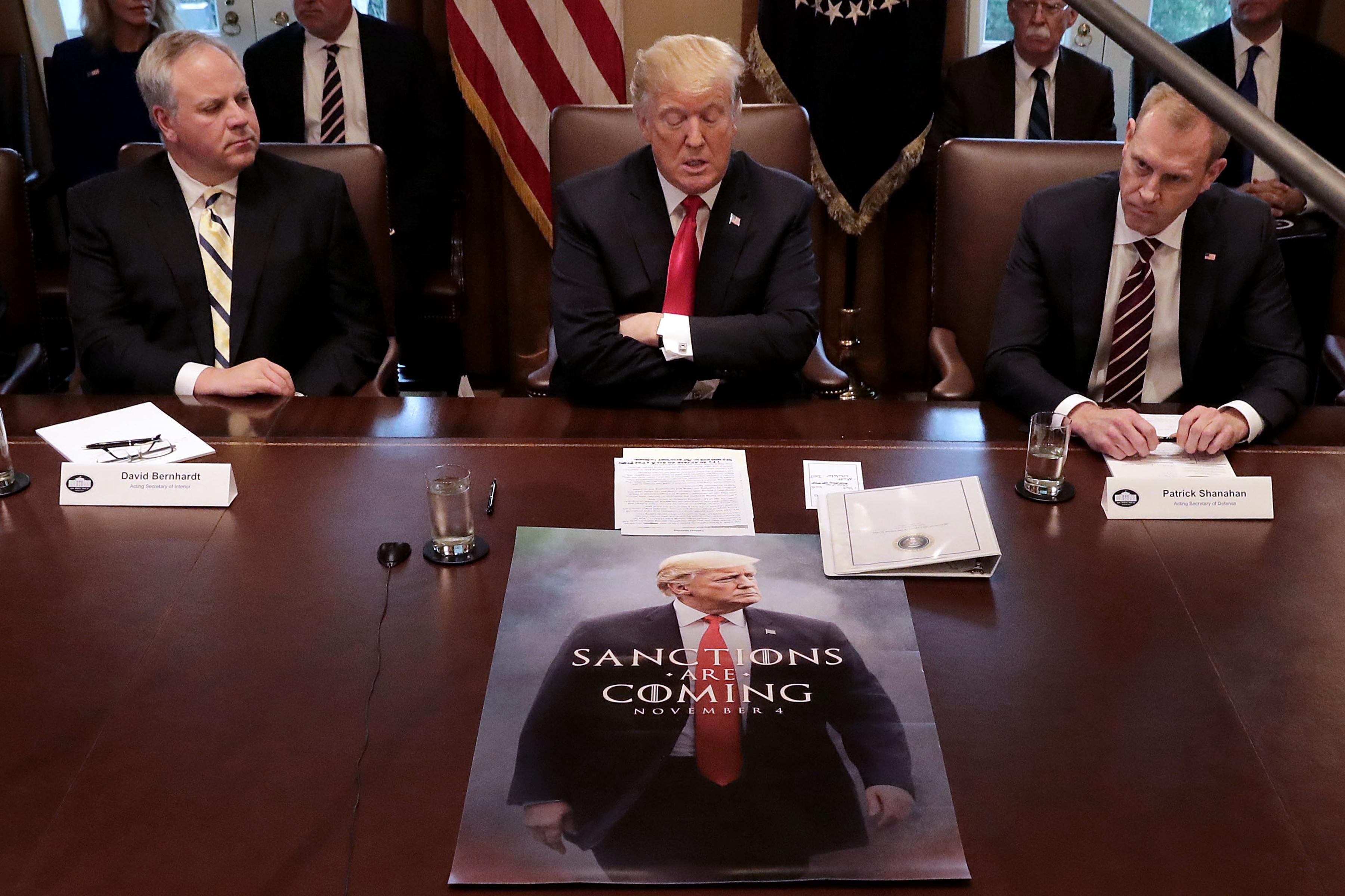 President Trump sits in front of a Game of Thrones knock off poster during a cabinet meeting after saying earlier he would "look foolish" if he opened the government without wall funding. 