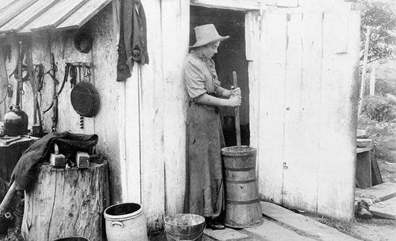 A woman churns butter in 1893.